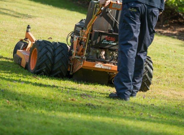 Man with commercial lawn mower cutting the grass