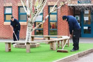 countrywide grounds staff sweeping artificial grass